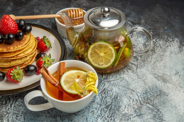 Panquecas saborosas de frente com frutas frescas no café da manhã com frutas frescas