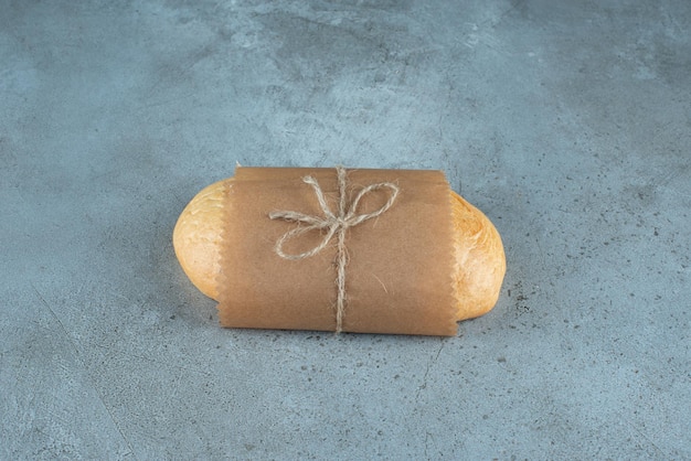 Foto grátis pão amarrado com corda na superfície de mármore.
