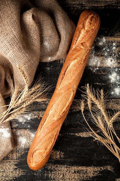 Pão baguete com farinha e trigo na mesa