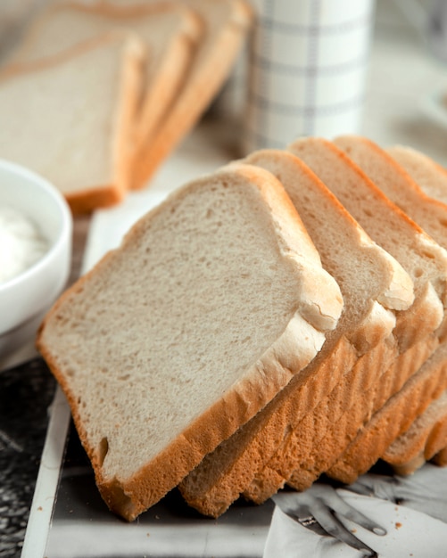 Pão branco fatiado em cima da mesa