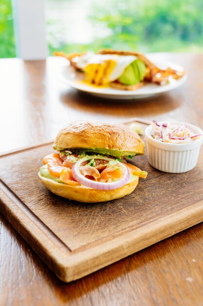 Pão de bagel com carne de salmão defumado e legumes