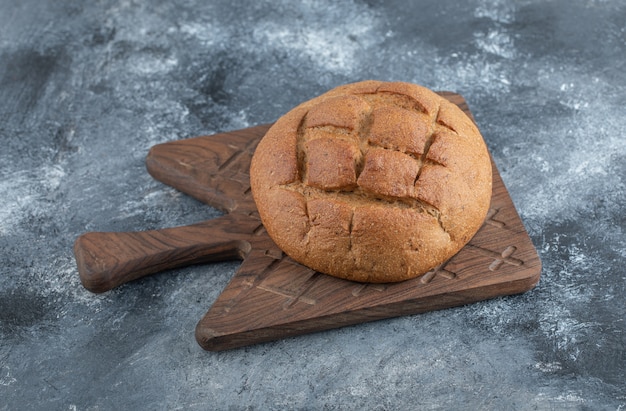 Pão de centeio caseiro fresco na placa de madeira. Foto de alta qualidade