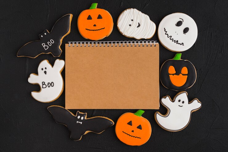 Foto grátis pão de gengibre de halloween em torno de notebook