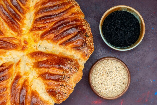 Pão de massa assada com arroz cru em fundo escuro.