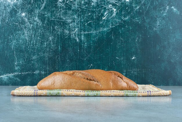 Pão delicioso marrom na toalha de mesa colorida.