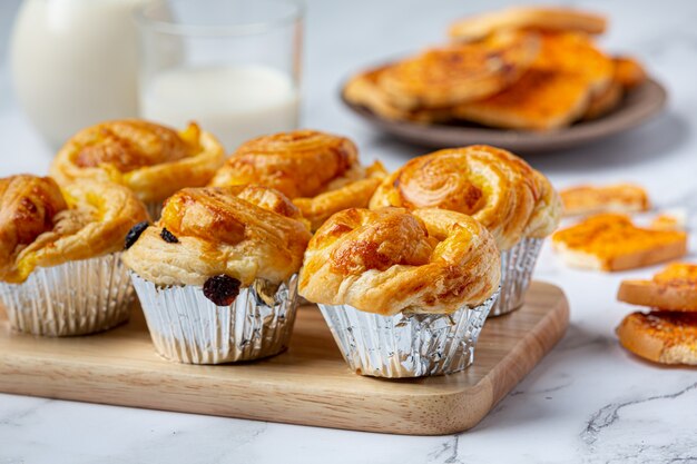 Pão dinamarquês fresco com leite e frutas, mirtilo, molho de cereja servido com leite.