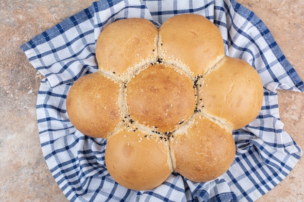 Pão em forma de flor fresca em toalha de mesa listrada