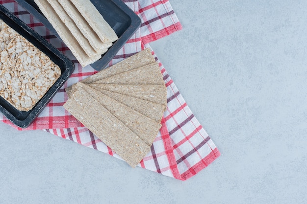 Foto grátis pão estaladiço e bolo de arroz tufado na toalha no mármore.