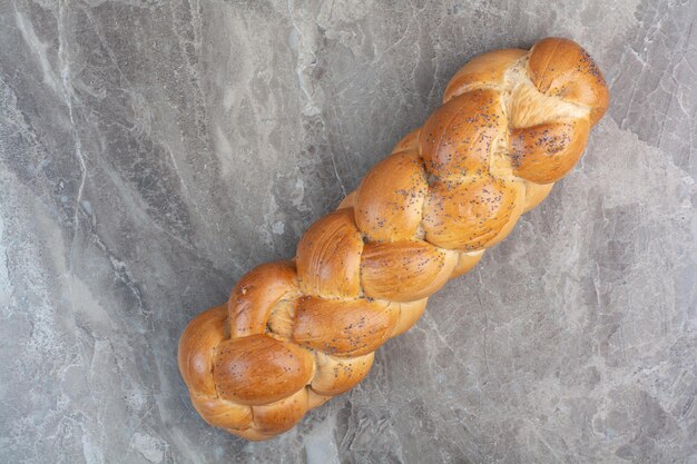 Pão fresco com sementes de papoula em fundo de mármore. foto de alta qualidade