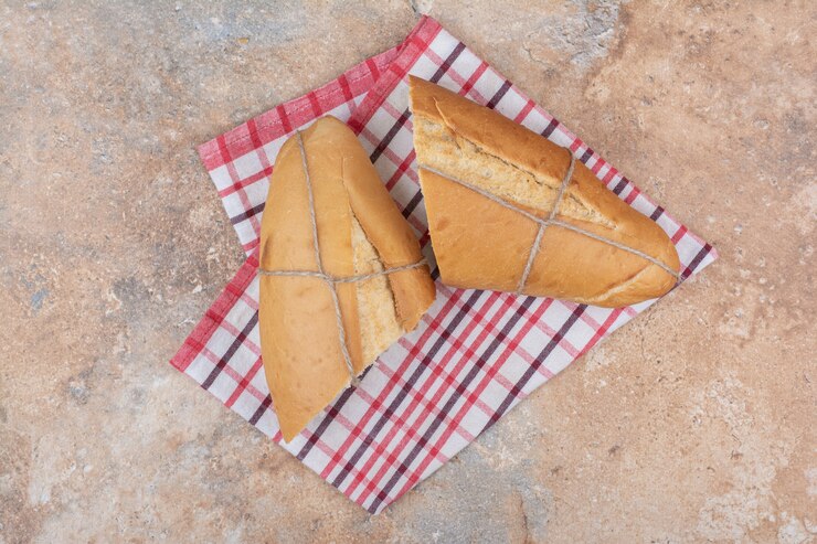 Foto grátis pão fresco com toalha de mesa sobre fundo de mármore