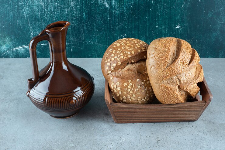 Foto grátis pão fresco em caixa de madeira com garrafa clássica.