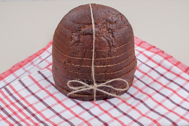 Pão integral fresco fatiado em corda na toalha de mesa