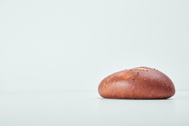 Pão oval feito à mão na mesa cinza.