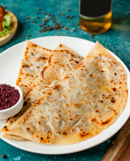 Pão sírio recheado com gutab do Azerbaijão com carne picada, servido com sumagre