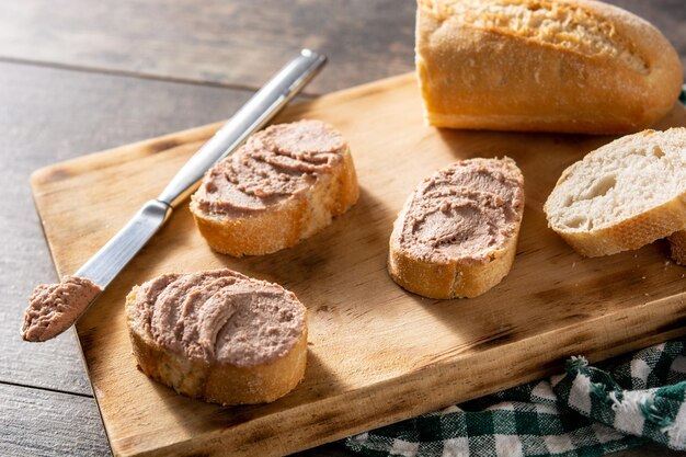 Pão torrado com patê de fígado de porco na mesa de madeira