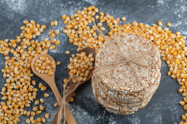 Pão torrado na corda com colheres de pau de sementes de pipoca crus.