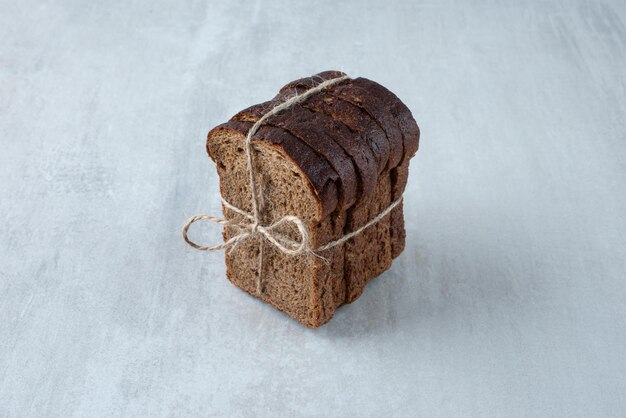 Pão torrado preto amarrado com superfície de pedra de corda.