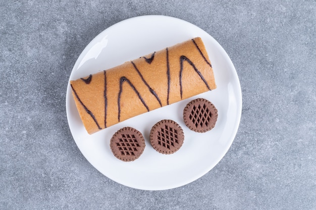 Foto grátis pãozinho doce delicioso e biscoitos no prato branco