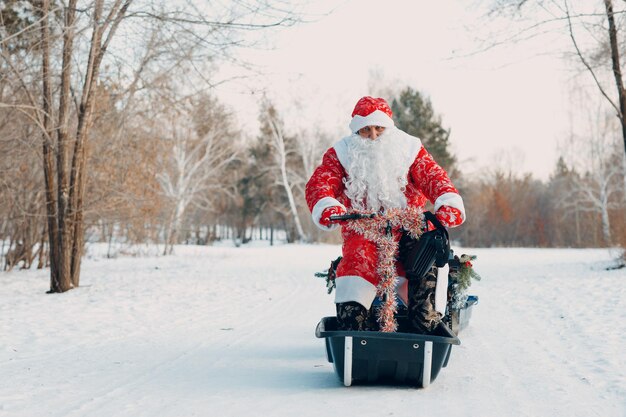 Papai noel andando de moto de neve na floresta de inverno