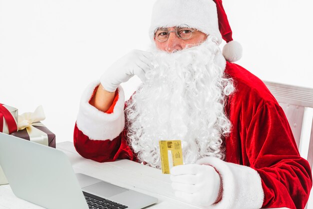 Papai Noel com laptop e cartão de crédito