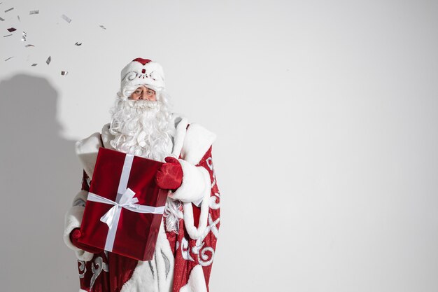 Papai Noel com presente de natal vermelho posando no estúdio