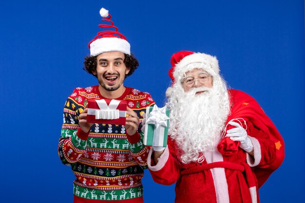 Papai Noel com um jovem segurando presentes