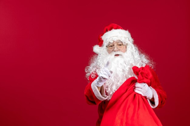Papai Noel com uma sacola vermelha cheia de presentes em um Natal vermelho