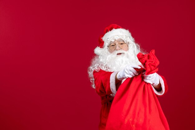 Papai Noel com uma sacola vermelha cheia de presentes na cor vermelha das emoções do feriado do ano novo
