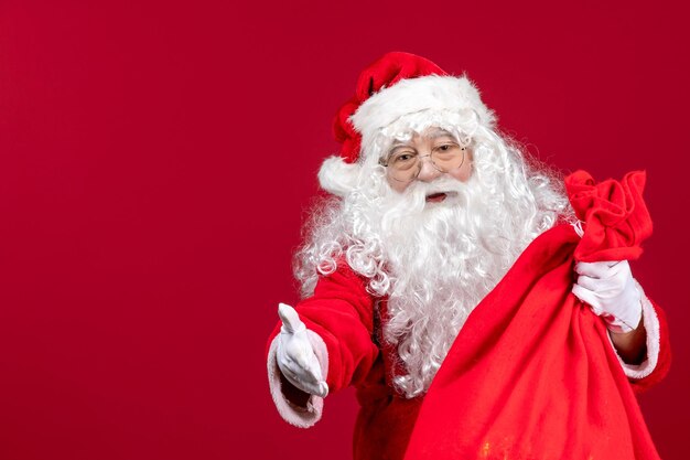 Papai Noel com uma sacola vermelha cheia de presentes na emoção do feriado do Natal do ano novo vermelho