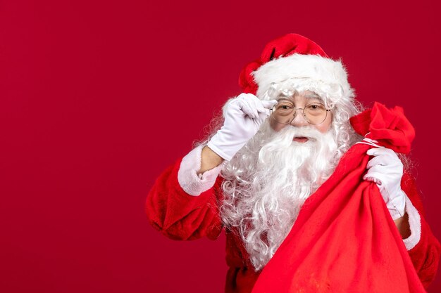 Papai Noel com uma sacola vermelha cheia de presentes para as crianças no feriado de Natal vermelho