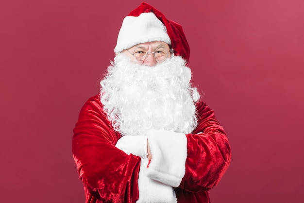 Papai Noel em pé cruzando os braços no peito