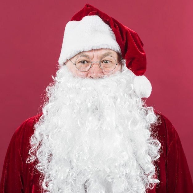 Papai Noel em pé de chapéu sobre fundo vermelho