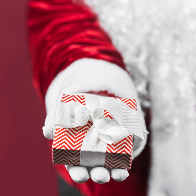 Papai Noel segurando a caixa de presente na mão