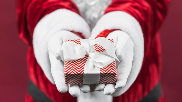 Papai Noel segurando a caixa de presente pequena nas mãos