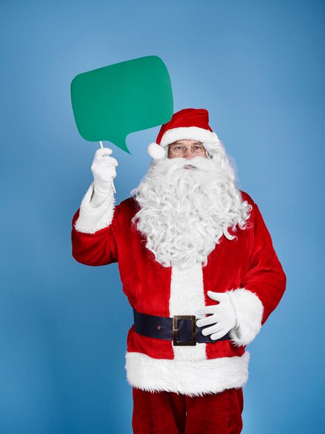 Papai Noel segurando um balão de fala em uma foto de estúdio