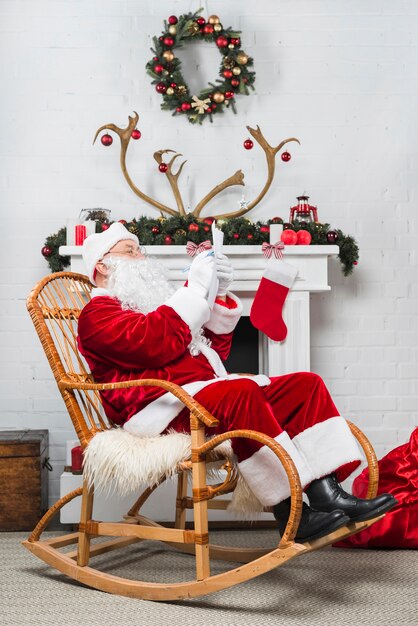 Papai Noel sentado no balancim com wishlist