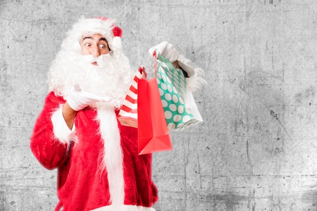 Foto grátis papai noel surpreendido com três presentes do natal