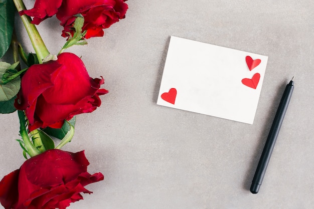 Foto grátis papel com pequenos corações perto de caneta e flores