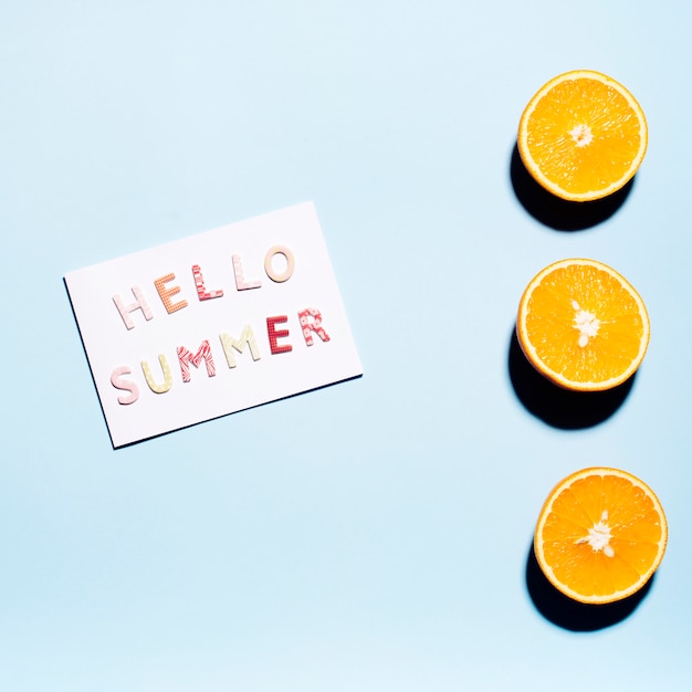 Foto grátis papel com texto olá verão com metades suculentas de laranjas