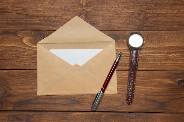 Papel em branco, envelope na mesa de madeira