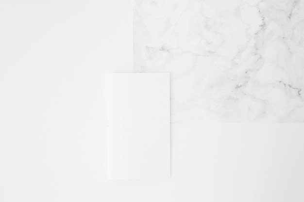 Papel em branco na textura de mármore contra o fundo branco