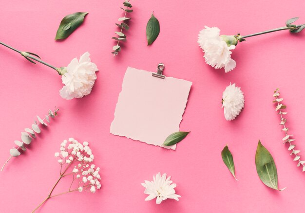 Papel em branco pequeno com flores na mesa