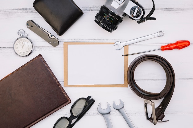 Foto grátis papel perto de câmera, notebook, cronômetro, equipamentos de reparo e pulseira de couro