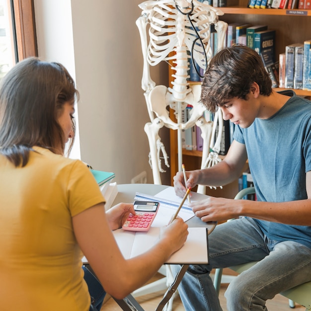 Foto grátis par adolescente, estudar, em, biblioteca