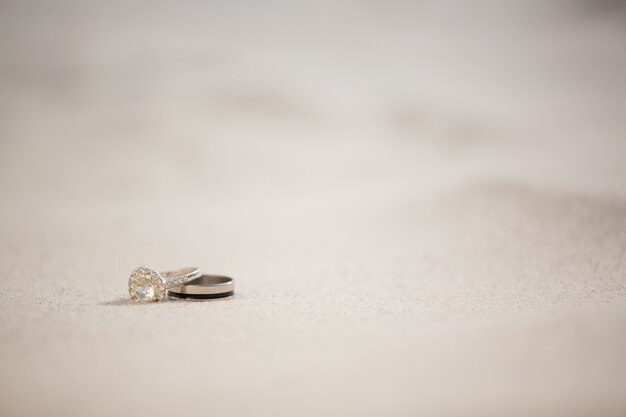 Par de anel de casamento na areia