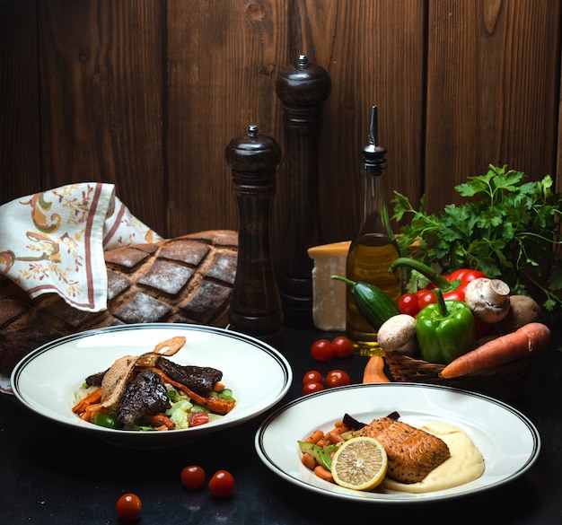 Par de carne frita e salmão em cima da mesa