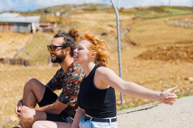 Par jovem, carona, ligado, à margem estrada