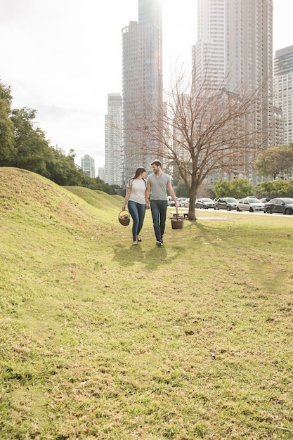 Foto grátis par jovem, carregar, cesta vime, andar, junto, parque