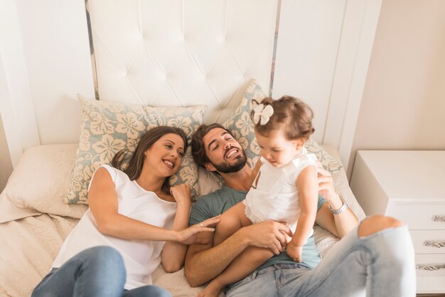 Par jovem, com, filha, mentindo cama