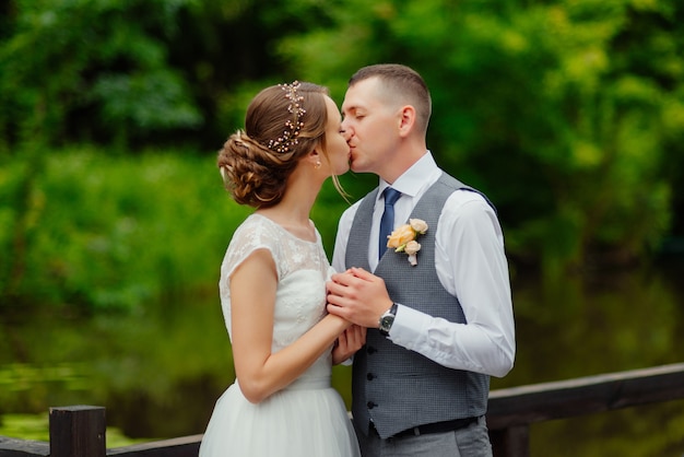 Par jovem, em, amor, beijando, noivo noiva, em, vestido casamento